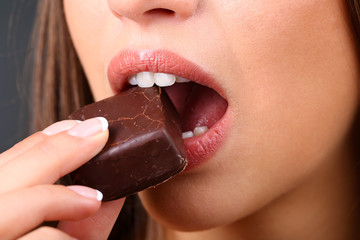 Closeup of woman eating chocolate candy