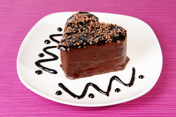 Sweet cake with chocolate on plate on table close-up