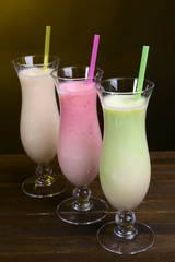 Milk shakes on table on dark yellow background
