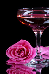 Composition with pink sparkle wine in glass and  rose isolated