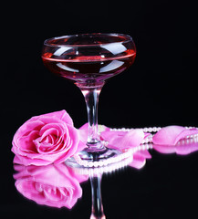 Composition with pink sparkle wine in glass and  rose isolated
