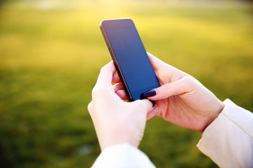 Closeup image of a female hands using smartphone