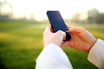 Closeup image of a female hand using smartphone