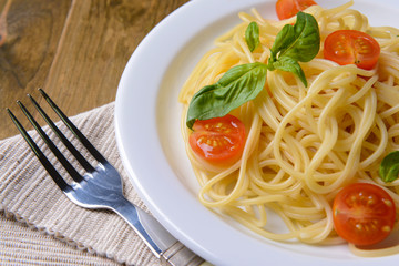 Delicious spaghetti with tomatoes on plate on table close-up