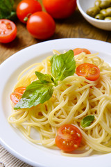 Delicious spaghetti with tomatoes on plate on table close-up