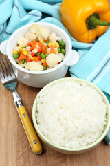 Cooked rice with vegetables on wooden table