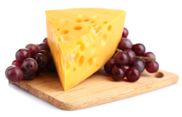 Piece of cheese and grape on wooden board, isolated on white