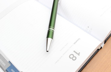 Closeup of green pen on notebook organizer