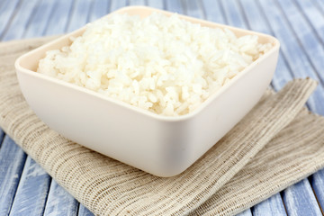 Cooked rice in bowl on wooden background