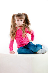 Little girl with long curly hair in a pink blouse