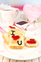 Delicious toast with jam and cup of tea on table close-up