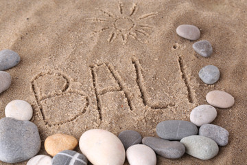 Fototapeta na wymiar Napis Bali na mokrym piasku tle bliska