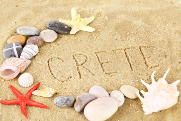 Fototapeta na wymiar Napis Kreta w mokrym piasku tle bliska