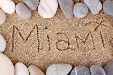 Fototapeta na wymiar Inscription Miami in wet sand close-up background