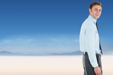 Composite image of happy businessman standing with hand in