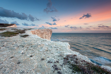 Pastel sunset over white sea cliffs - 61345363