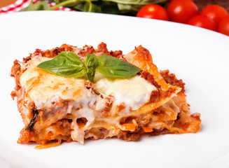 Tasty lasagna on white plate close-up