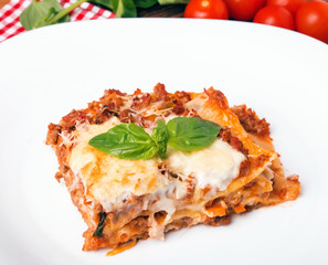 Tasty lasagna on white plate close-up