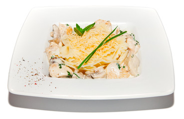 Pastai with chicken, creamy sauce and cheese, salad on plate