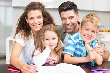 Parents colouring with their children at the table