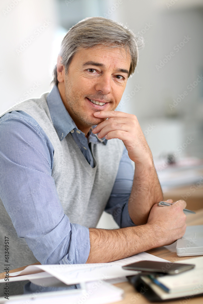 Wall mural Portrait of senior businessman in office