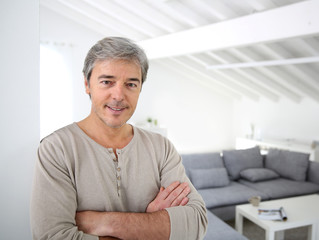 Mature handsome man standing in modern house