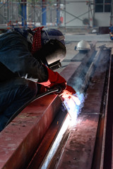 Welder with protective mask welding metal and sparks