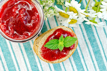 Bread with strawberry jam and daisies on napkin top