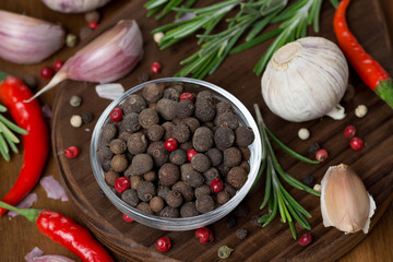 dried peppers, garlic, chilli and rosemary on a wooden board