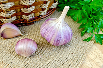 Garlic with burlap and a basket on the board