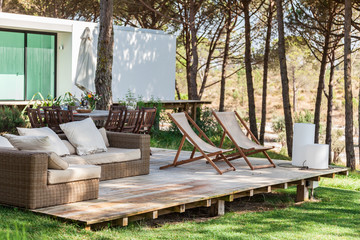 Summer house deck with chairs and sofa