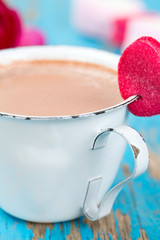 hot chocolate and heart-shaped marshmallow on wooden surface