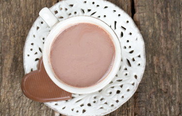 hot chocolate and chocolate heart on wooden surface