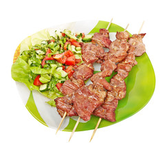 kebab and salad on a green plate, isolated on white background
