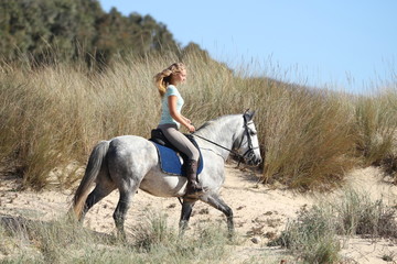 Blonde Reiterin in den Dünen