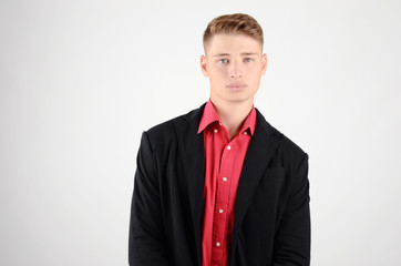 Fototapeta premium Portrait of a young business man wearing a suit and a red shirt.