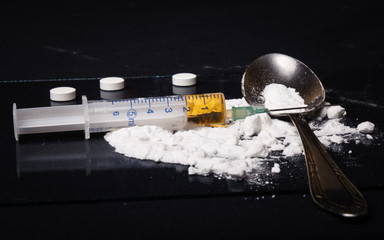 Drug syringe and cooked heroin on spoon