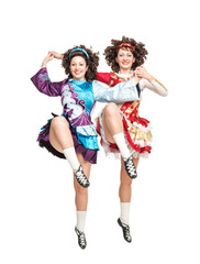 Two young women in irish dance dress dancing isolated