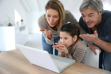 Parents with kids making a distant call on internet