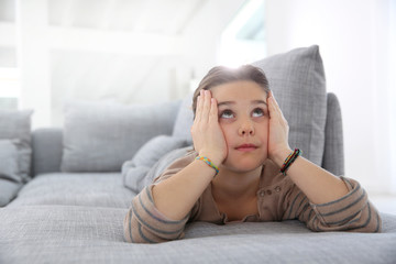 Little girl on couch looking to the ceiling