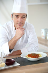 Portrait of chef in kitchen preparing italian dish