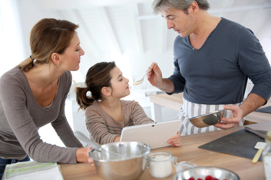Family in home kitchen preparing pastry