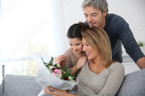 Family celebrating mother's day with bunch of flowers