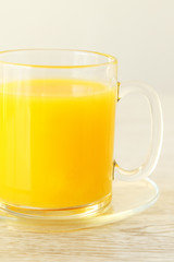 A glass mug full of orange juice