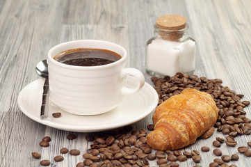 Croissant with coffee beans around