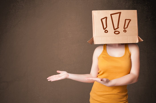 Young lady gesturing with a cardboard box on her head with excla
