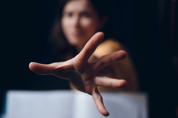 Hand protruding out from an open book