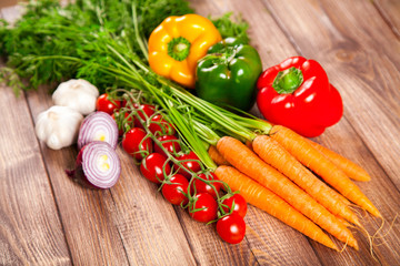 Carrot, tomato and paprika on a wooden table