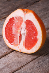 Sliced ​​ripe grapefruit on an old wooden, vertical
