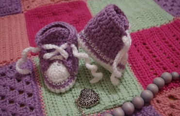 nice baby's bootees on crochet blanket